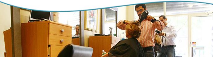 A man blow drying a woman's hair. 